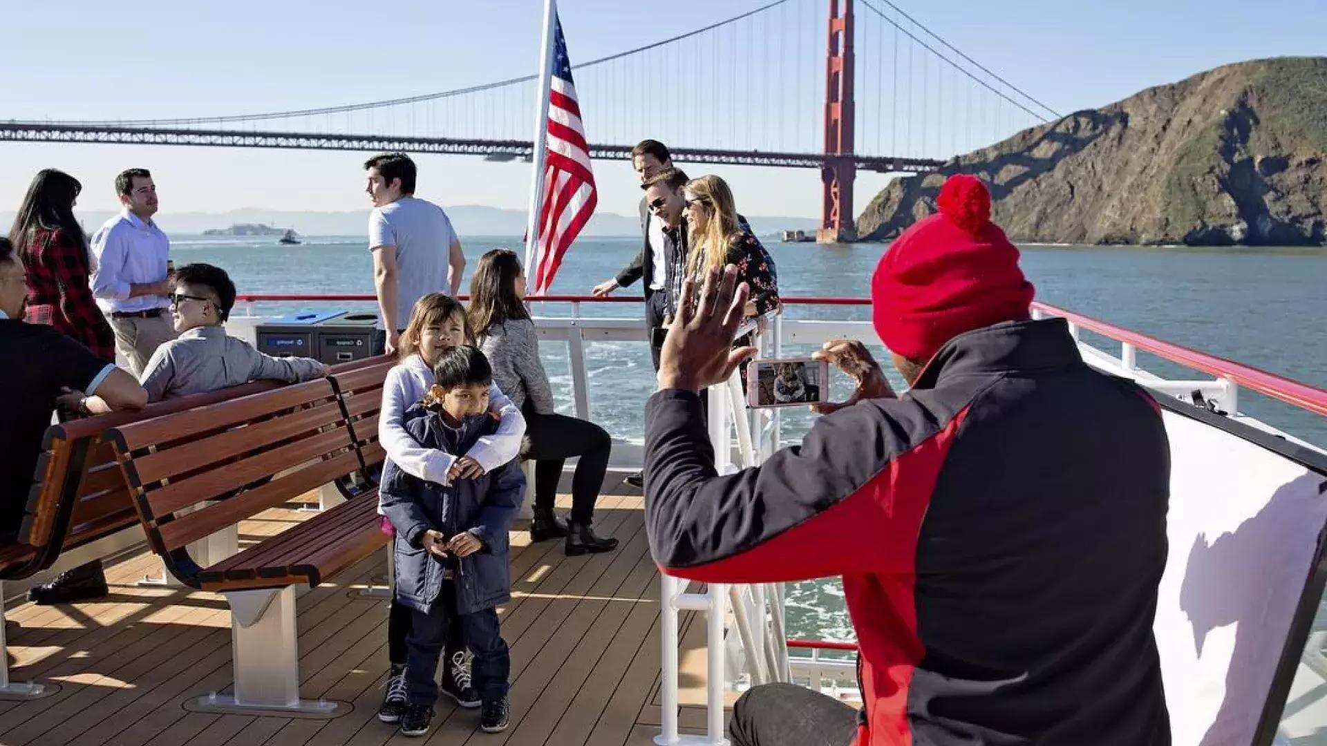 A family enjoys a cruise on the bay, passing the Golden Gate Bridge.