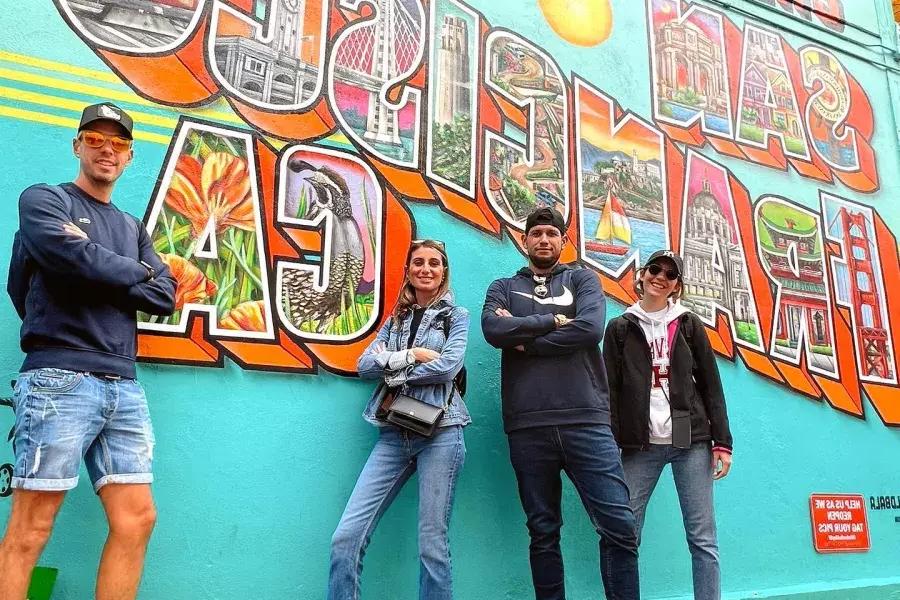 Les visiteurs branchés posent devant une fresque murale de San Francisco.