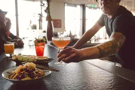 在贝博体彩app的酒吧里，调酒师为顾客提供鸡尾酒.