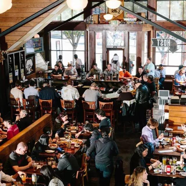 Les clients mangent et boivent à l'intérieur de la brasserie 21st Amendment à San Francisco.